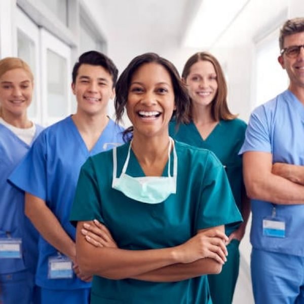 Portrait Of Laughing Multi-Cultural Medical Team Standing In Hospital Corridor